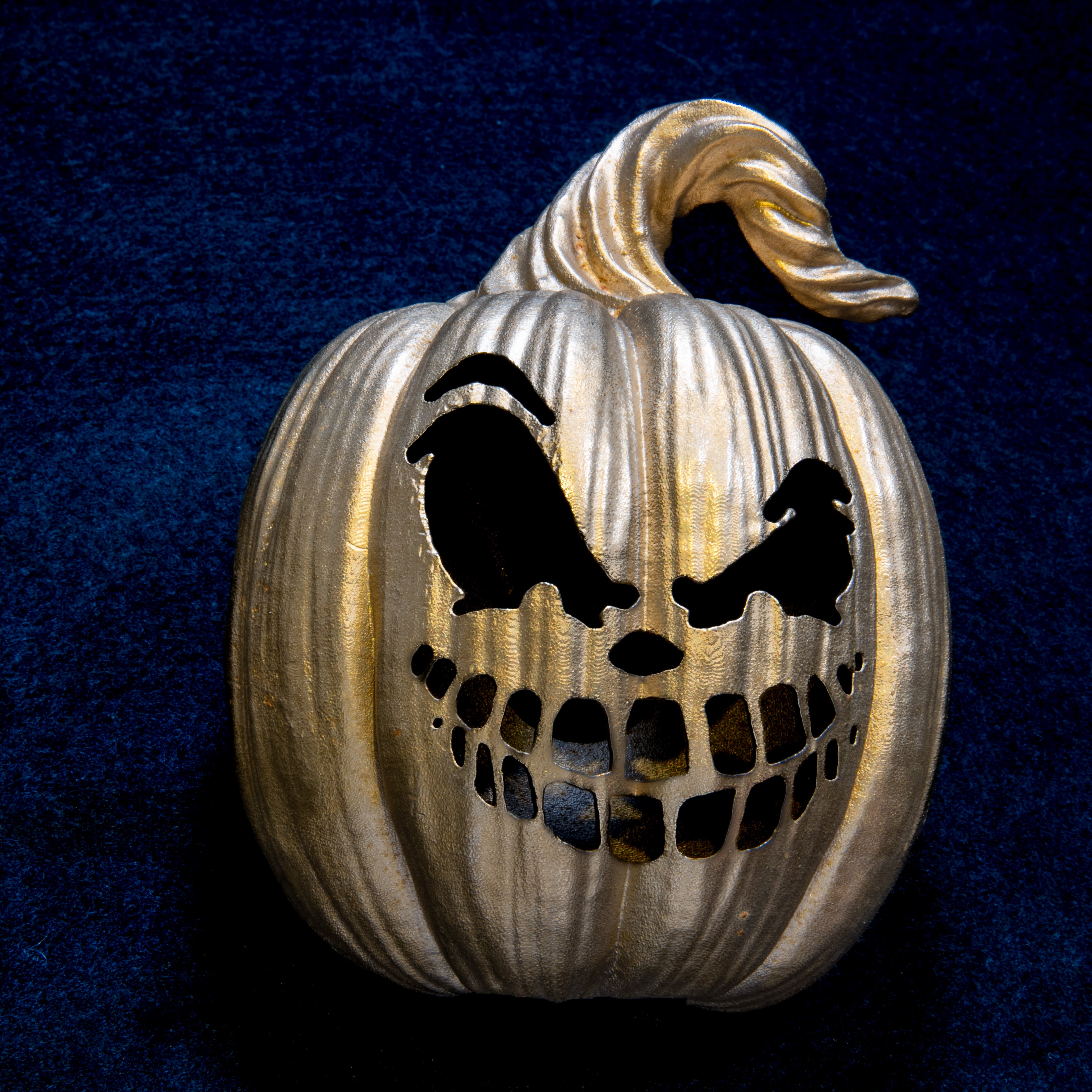 Halloween collection: Smirking Jack-o'-Lantern door knocker head on navy cloth, one arched brow and two rows of square teeth