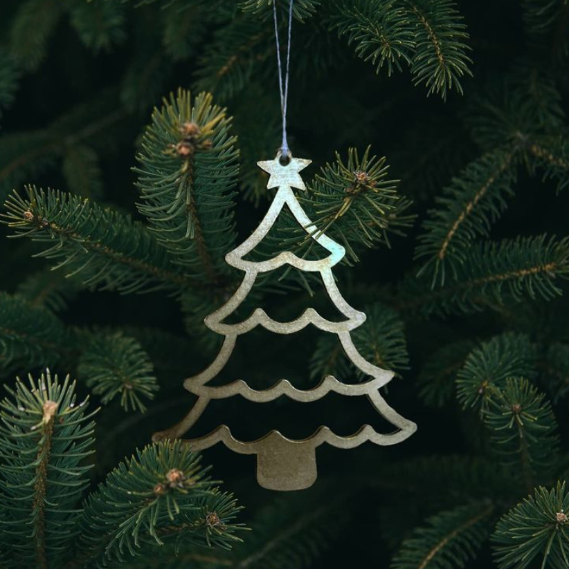 Christmas Decorations collection: tree-shaped decoration with a star and scalloped tiers, hanging on a white string in a fir