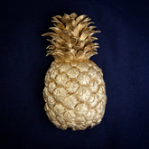 Pineapple interchangeable door knocker head, front view on navy cloth, crown of pointed leaves over rows of scaled segments