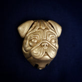 Pug interchangeable door knocker head, front view on navy cloth, deep wrinkles over a flat nose, ears folded forward