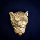 Tiger interchangeable door knocker head, front view on navy cloth, stripes across the brow and folds of fur under the chin