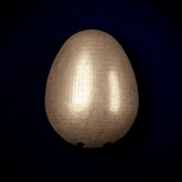 Egg interchangeable door knocker head on a dark blue background, a plain smooth egg with a soft polished sheen