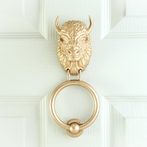 Beardless Bison brass door knocker on a pale front door