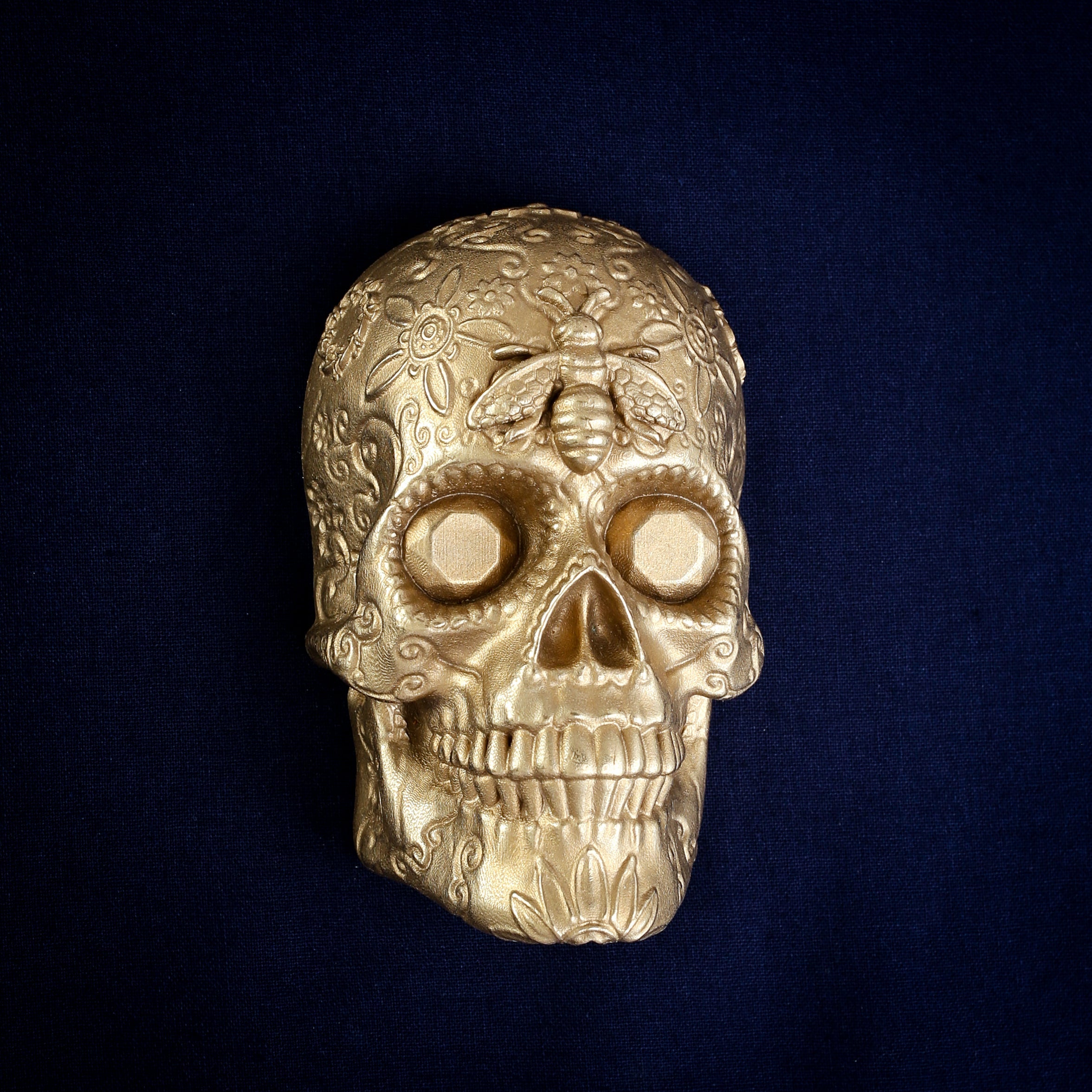 Bee and Diamond Sugar Skull interchangeable door knocker head on navy, front view, a bee on the brow above bright eye sockets