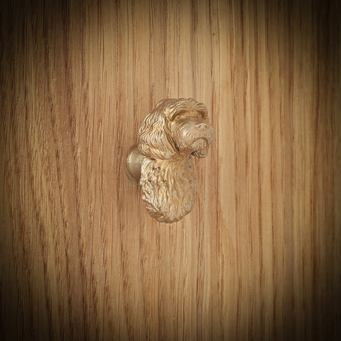 Cavapoo brass cabinet knob, side view on a wooden board