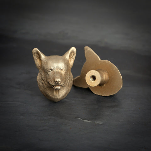 Corgi brass cabinet knob and coat hook on dark slate, one facing front, one turned to show the threaded back