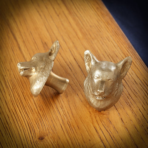 Corgi brass cabinet knob and coat hook on an oak board, one on its side showing the stem, one facing front
