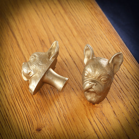 French Bulldog brass cabinet knob and coat hook on an oak board, one on its side showing the stem, one facing front