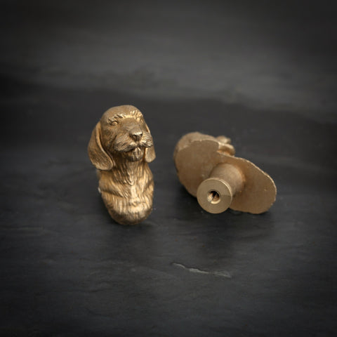 Long-Haired Dachshund brass cabinet knob and coat hook on dark slate, one facing front, one turned to show the threaded back