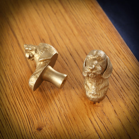 Long-Haired Dachshund brass cabinet knob and coat hook on an oak board, one on its side showing the stem, one facing front