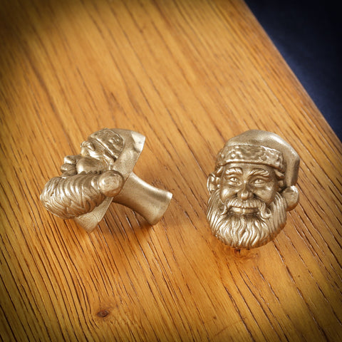 Santa brass cabinet knob and coat hook on an oak board, one on its side showing the stem, one facing front