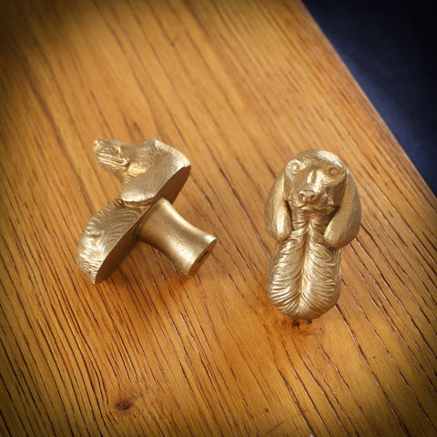 Short-Haired Dachshund brass cabinet knob and coat hook on an oak board, one on its side showing the stem, one facing front