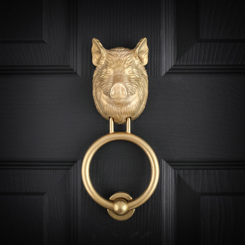 Yorkshire Pig brass door knocker in cast aluminium bronze on a black front door, straight on